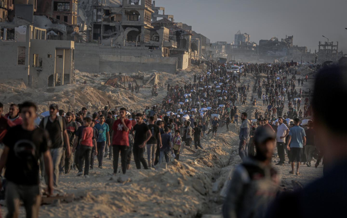 Palestinians flock to the aid center set up by the US and Israeli-created Gaza Humanitarian Foundation on the Coastal Road in the Sudaniya area.