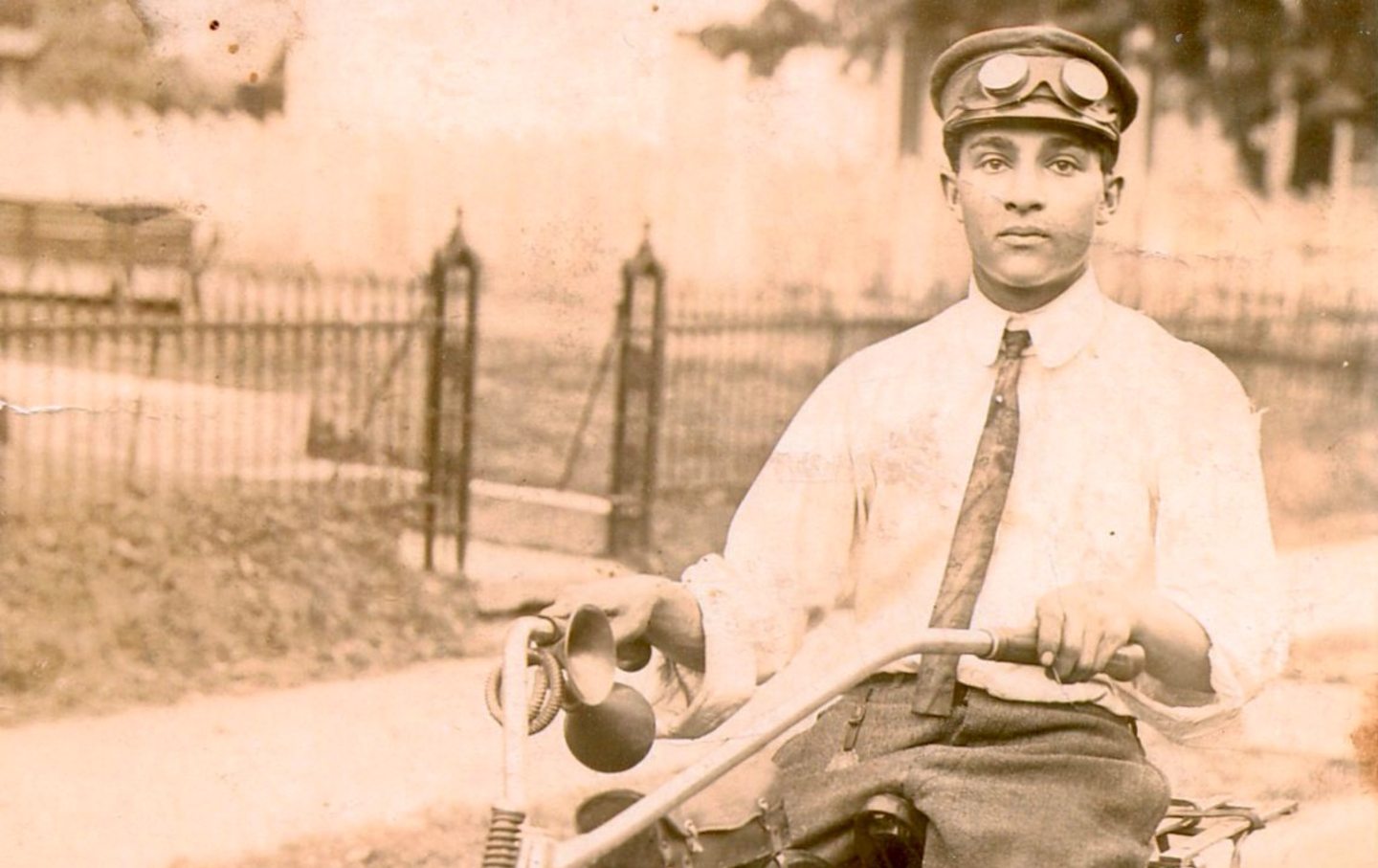 A man in a collared shirt and tie rides a motorcycle in Little Rock, Arkansas.
