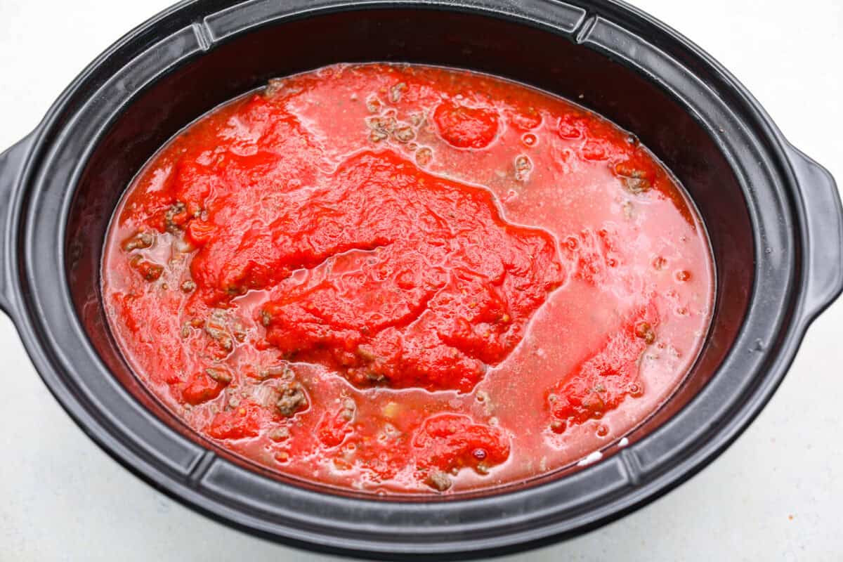 Water poured on top of the last layer of pasta sauce. 