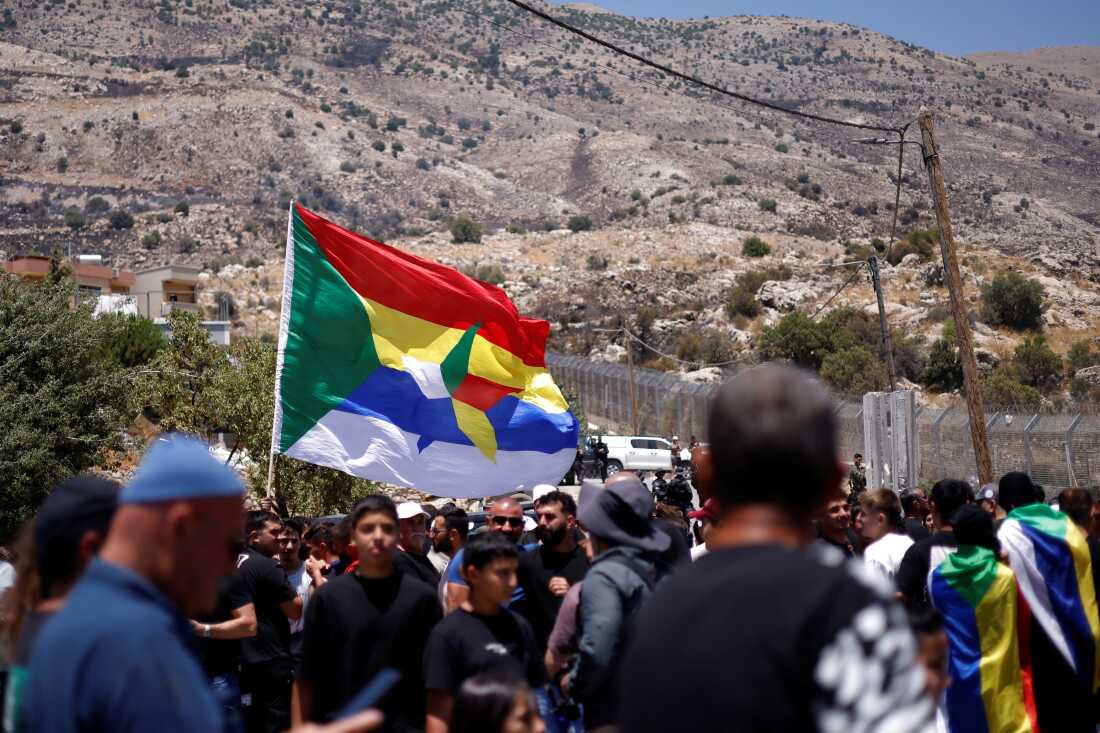 Druze wait near the border fence in the Israeli-annexed Golan Heights village of Majdal Shams, as Syrian Druze who'd crossed over the day before return to Syria following days of sectarian bloodshed in the southern Syrian region of Sweida, July 17.
