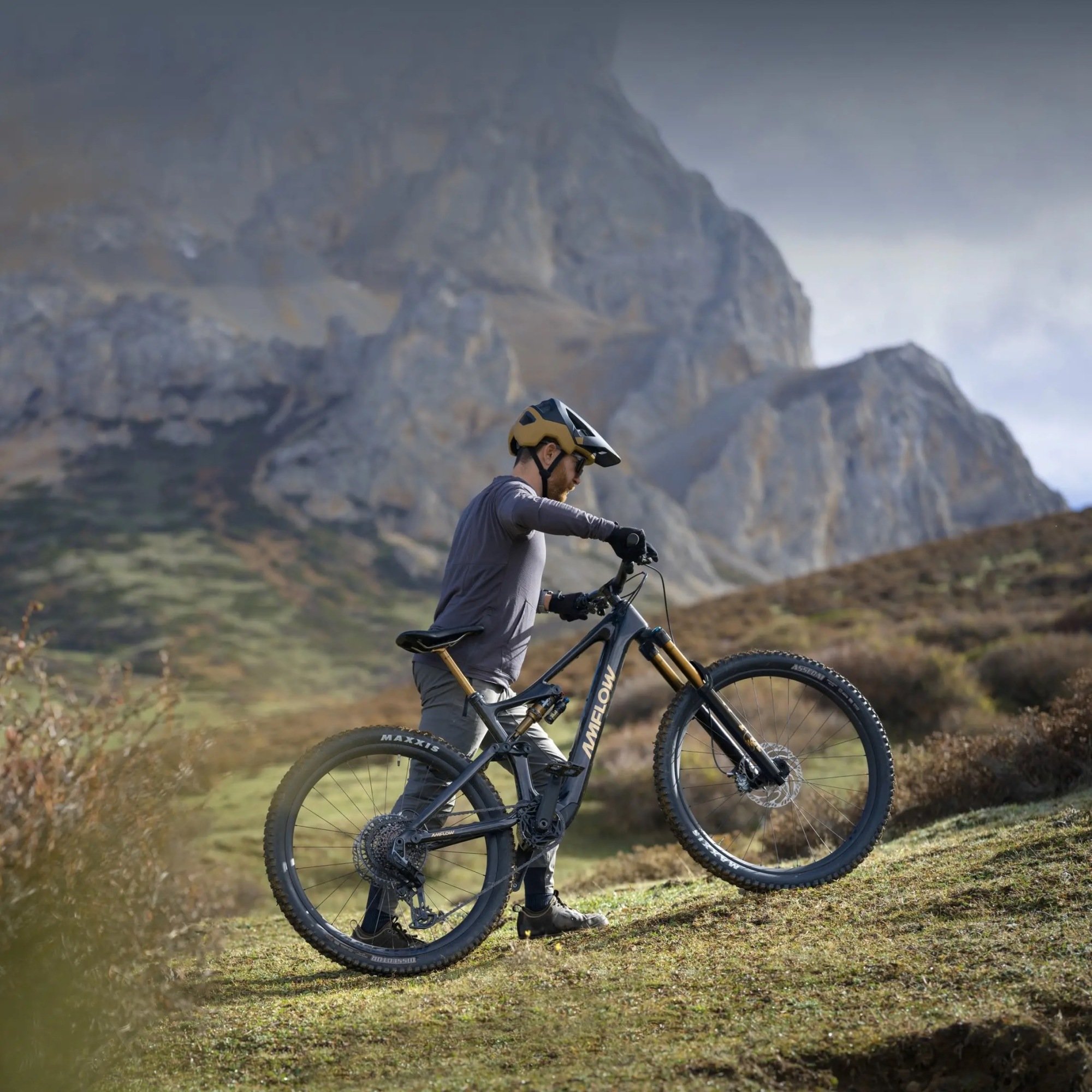 man pushing amflow e-bike up mountain