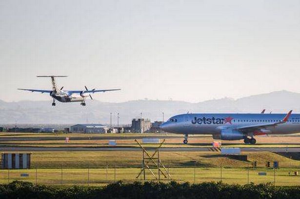 Air New Zealand ZK-NEO touching down. Jetstar VH-VFP Airbus A320 on the runway at Auckland International Airport.