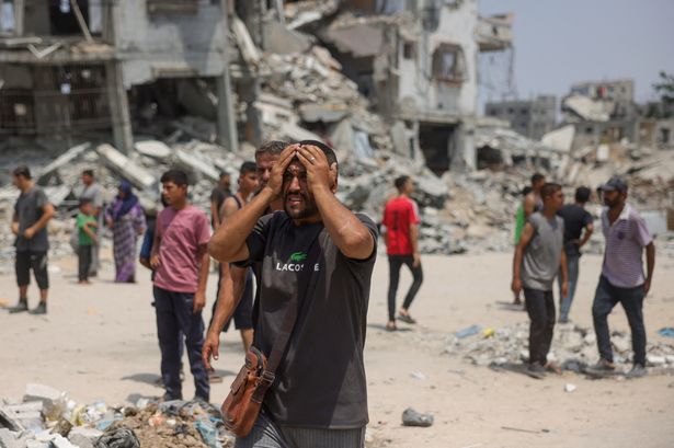 Man reacts as medics transport casualties of Israeli strikes on volunteers
