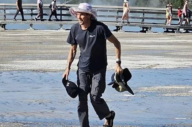 Man walking in flip-flops over a delicate ecosystem in Yellowstone National Park