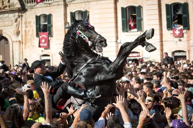 A horse rears in the crowd during the "Caragol des Born", a mass gathering of horses and people swirling to the rythm of the music during the traditional Sant Joan (Saint John) festival in the town of Ciutadella, on the Balearic Island of Minorca, on the eve of Saint John