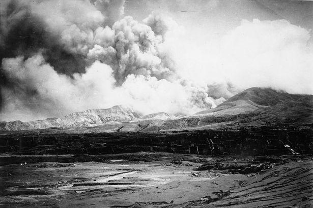 ST. PIERRE, MARTINIQUE - MAY 10: The city of St. Pierre lies in ruins after the eruption of the Mount Pelee volcano (in the background) in which 30,000 people were killed and only 2 survived 2 days after the eruption on May 10, 1902 at St. Pierre, Martinique. (Photo by Archive Farms/Getty Images)