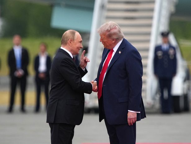 President Donald Trump greets Russian President Vladimir Putin as he arrives at Joint Base Elmendorf-Richardson