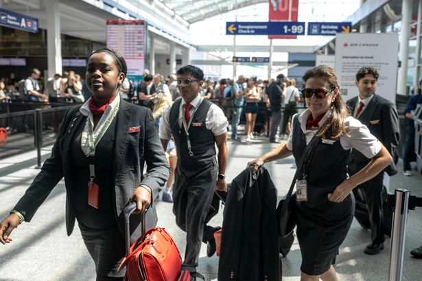 Air Canada flight crew walks by passengers