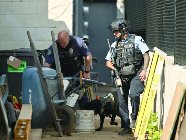 police officers search an alleyway near the scene of a shooting at annunciation catholic school in minneapolis minnesota photo afp