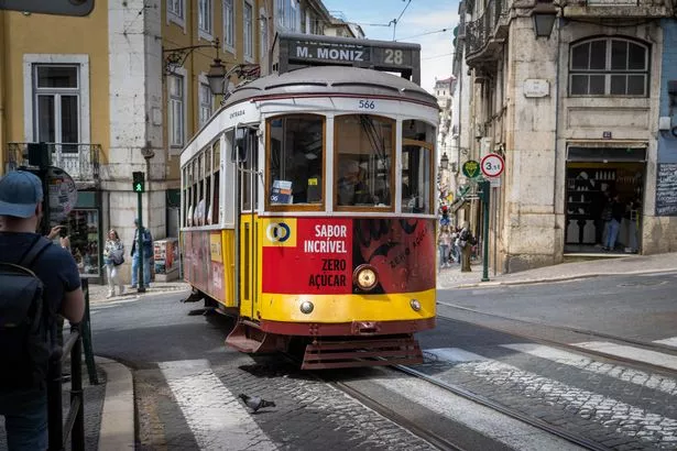 People take the historic tram for public transport in Lisbon, Portugal