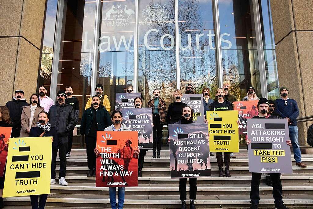 Greenpeace Australia activists in front of the Federal Courts of Australia. AGL, Australia’s largest energy company, has taken Greenpeace Australia to court over the use of the AGL logo in a Greenpeace campaign exposing AGL as Australia’s biggest climate polluter. Greenpeace staff David Ritter, Katrina Bullock, Glenn Walker and Maurice Blackburn principal lawyer Rebecca Gilsenan speak at the press conference outside the Federal Courts in Sydney. Over 20 Greenpeace activists hold an action behind the press conference. They stand with their mouths taped shut and hold signs defending Greenpeace’s right to freedom of expression.