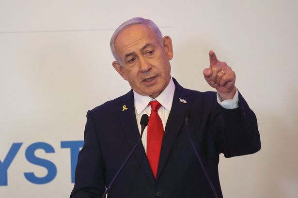 Netanyahu pictured speaking in a suit and tie