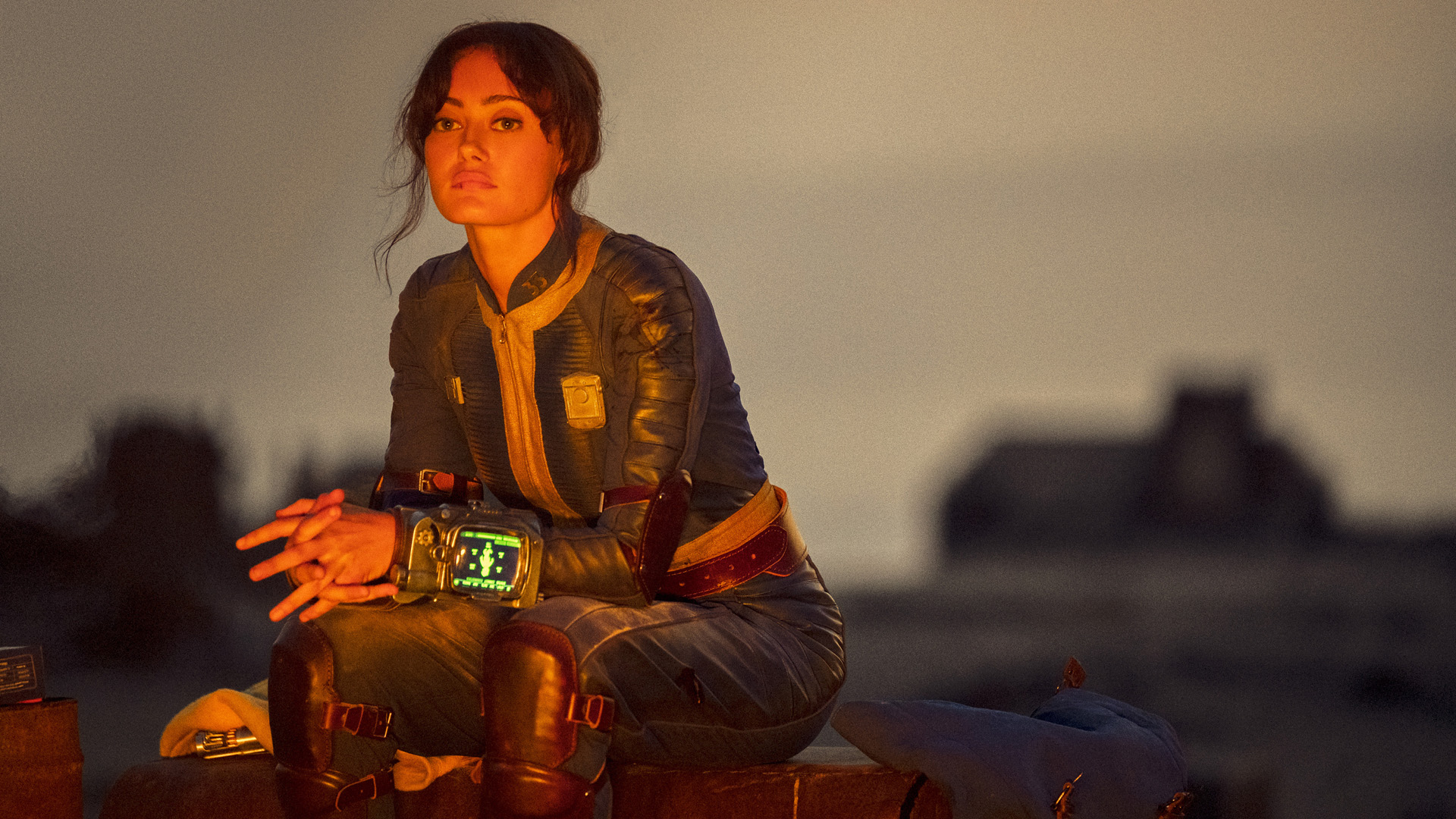 Lucy sits by a campfire as dusk sets in during Amazon