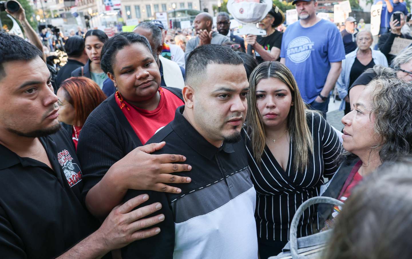 Kilmar Abrego Garcia and his wife Jennifer Vasquez Sura stand surrounded by a crowd of supporters.