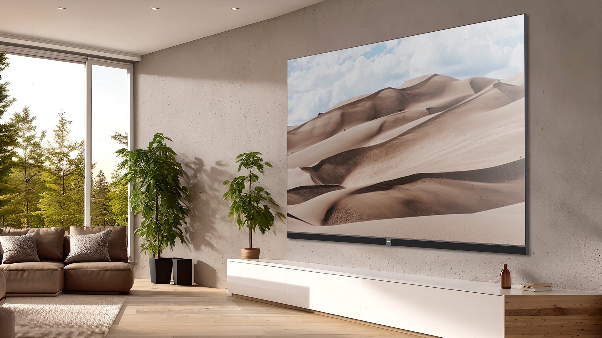 The very large Hisense 136MX on a wall. There are two large plants to the left and then a couch with a large window behind it