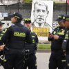 Police stand in front of a banner reading in Spanish "Uribe guilty" displayed by opponents of former President Alvaro Uribe outside the court where a verdict is expected in his trial for witness tampering in Bogota, Colombia, on July 28, 2025.