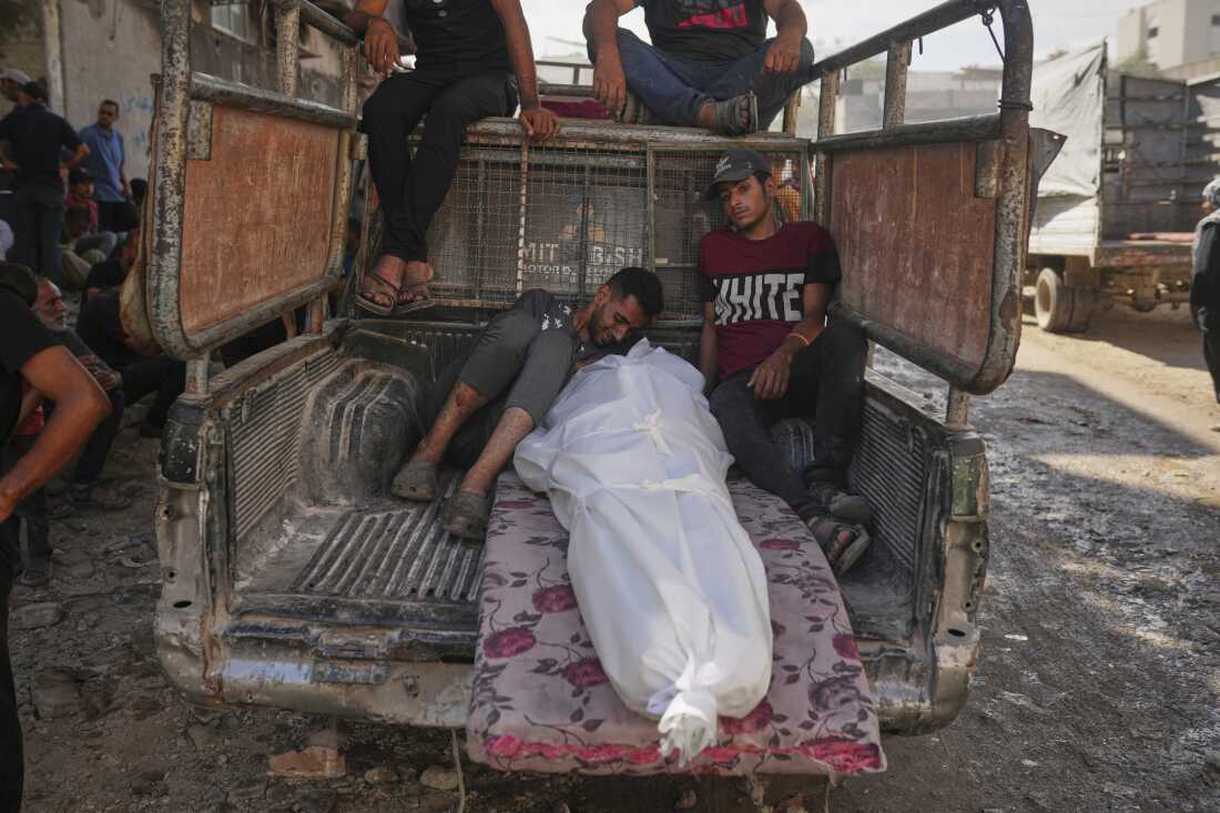 Palestinians mourn around the body of a man killed while trying to reach aid trucks entering northern Gaza through the Zikim crossing with Israel, at Shifa Hospital in Gaza City, Thursday, July 31, 2025.