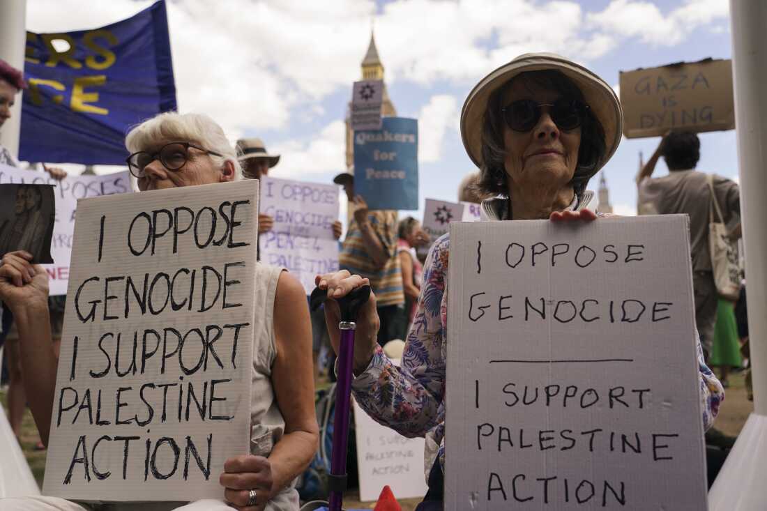 Demonstrators hold placards during a protest in support of the Palestinian People in Gaza, in Parliament Square, in London, Saturday, Aug. 9, 2025.