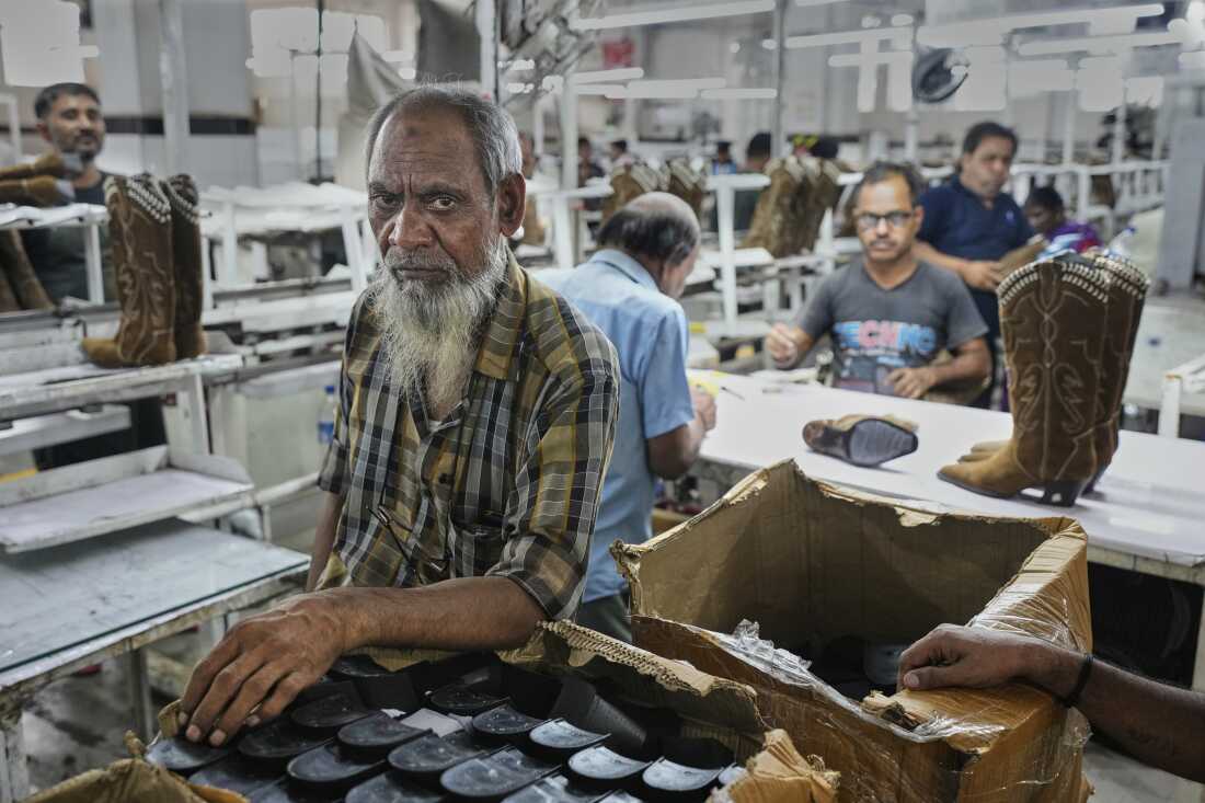 Workers at a manufacturing unit make leather footwear in Agra, India, on Monday.