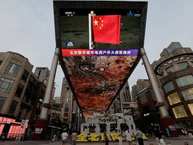 a large screen shows news footage of a chinese national flag carried by chang e 6 probe s lander on the far side of the moon in beijing china june 4 2024 photo reuters