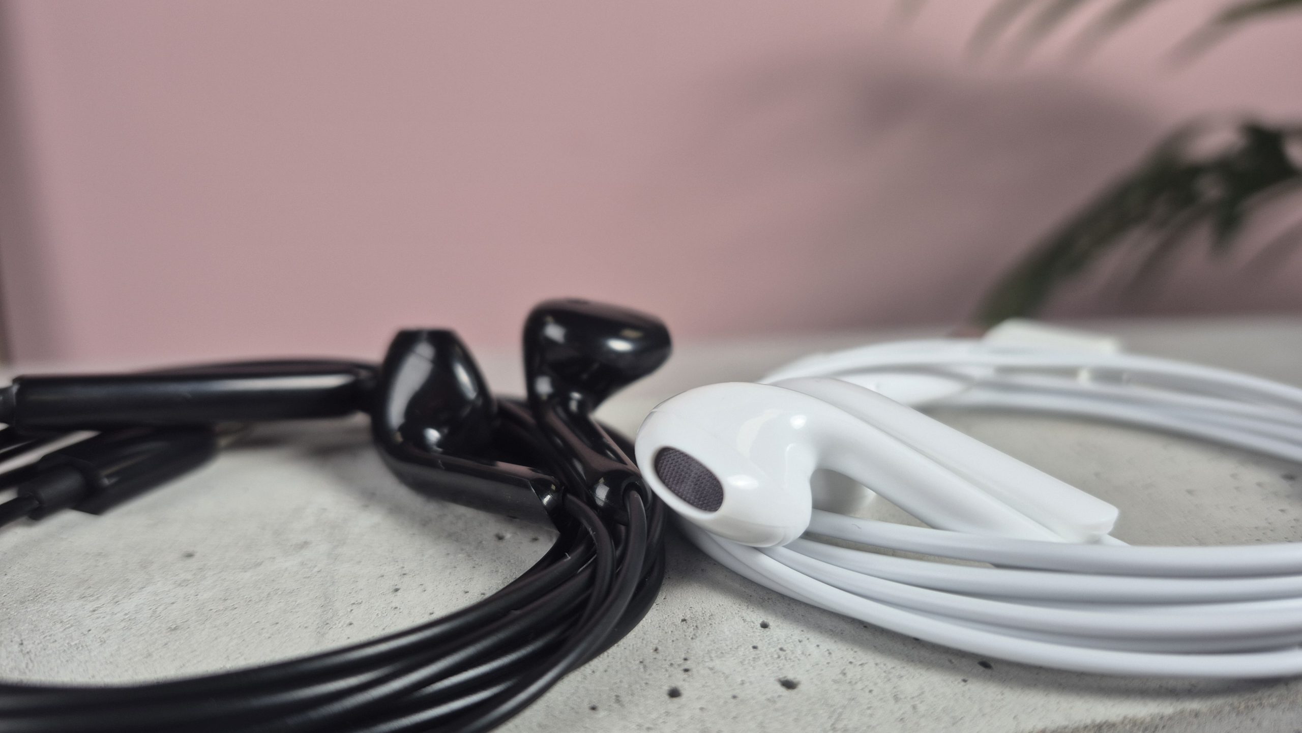 ZJXD wired earbuds on block against pink background