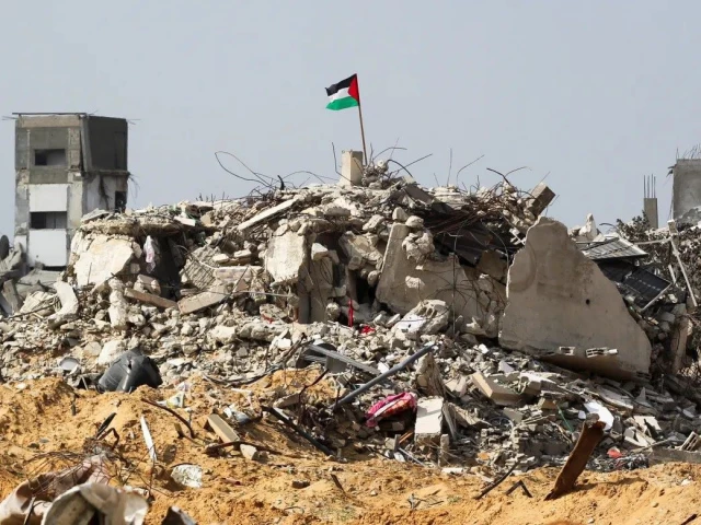 a palestinian flag flutters amid the rubble of buildings destroyed during the israeli offensive photo reuters