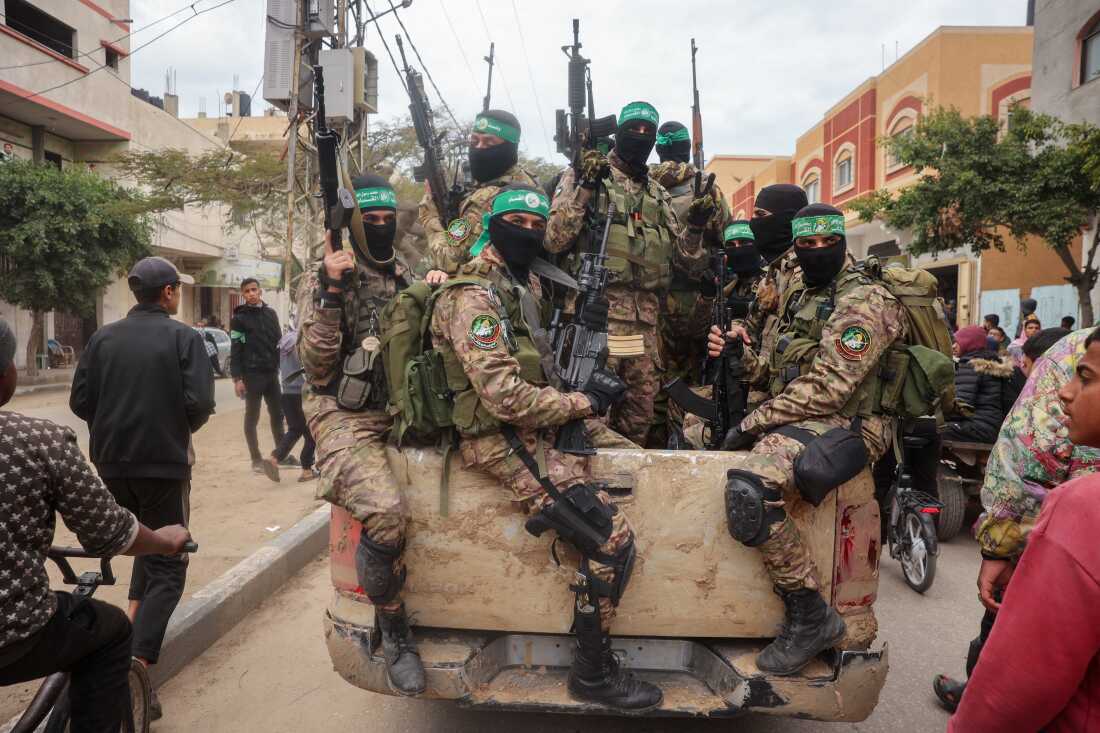 Hamas fighters patrol a street before they hand over three Israeli hostages to a Red Cross team in Deir el-Balah, central Gaza, on Feb. 8.