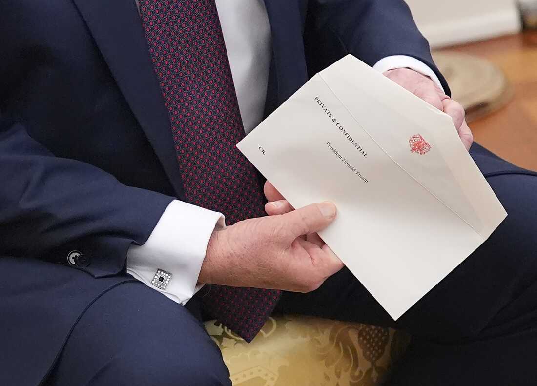 President Trump holds a letter from King Charles III given to him by British Prime Minister Keir Starmer during a meeting at the White House on Feb. 27.
