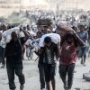 Palestinians carry bags and folded cardboard boxes as they return from a food distribution point run by the U.S. and Israeli-backed Gaza Humanitarian Foundation group, near the Netsarim corridor in the central Gaza Strip on Saturday.