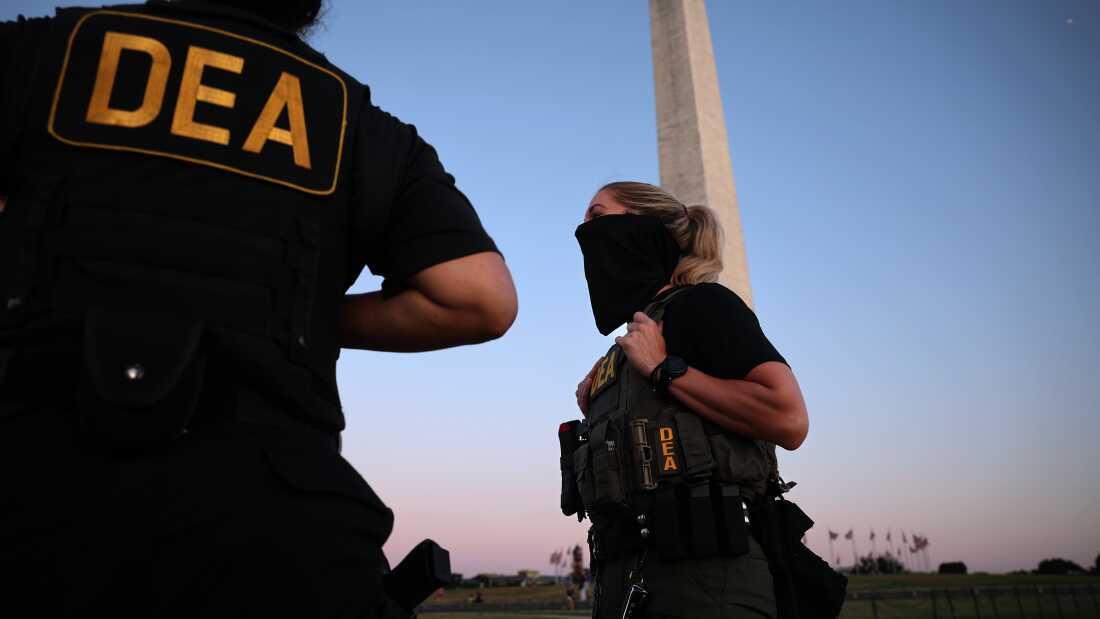 U.S. Drug Enforcement Administration (DEA) agents patrol near the Washington Monument on the National Mall on August 11 in Washington, D.C.