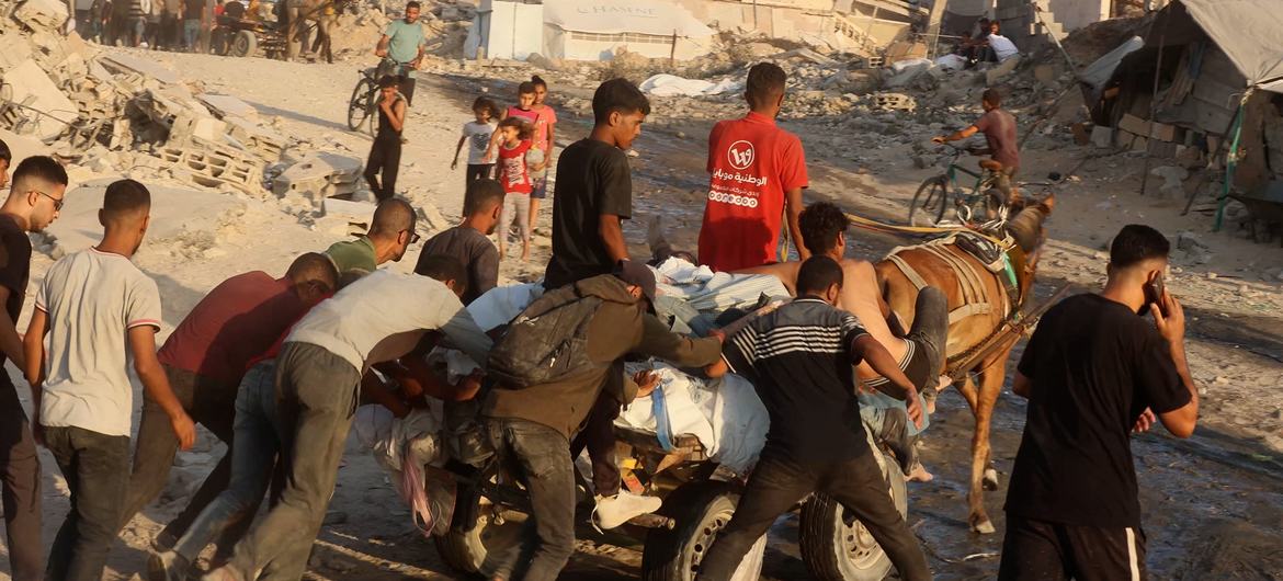 A horse-drawn cart carries the bodies of more than seven Palestinians killed while trying to reach aid.