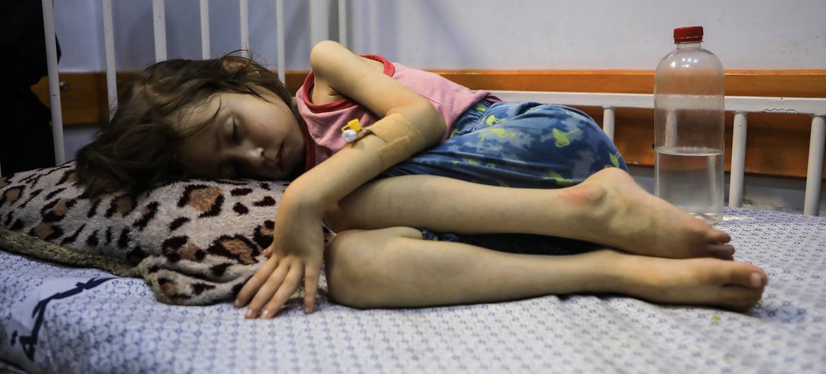 A child suffering from malnutrition lies on a bed in the Patient Society Hospital in Gaza City.