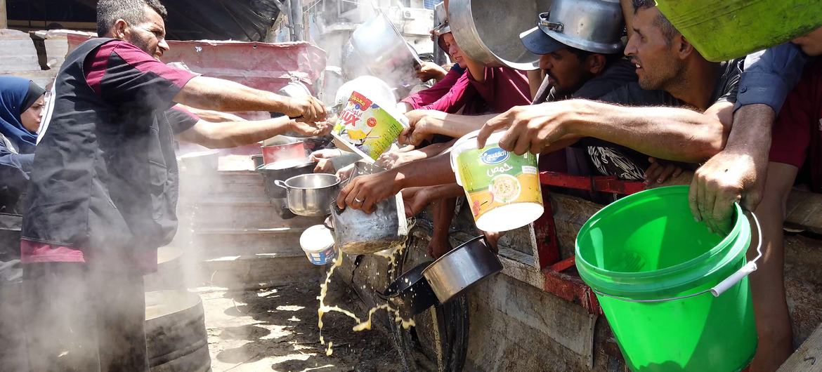 A group of displaced Palestinians gathering in front of a local community kitchen in western Gaza City. A group of displaced Palestinians gathering in front of a local community kitchen in western Gaza City.