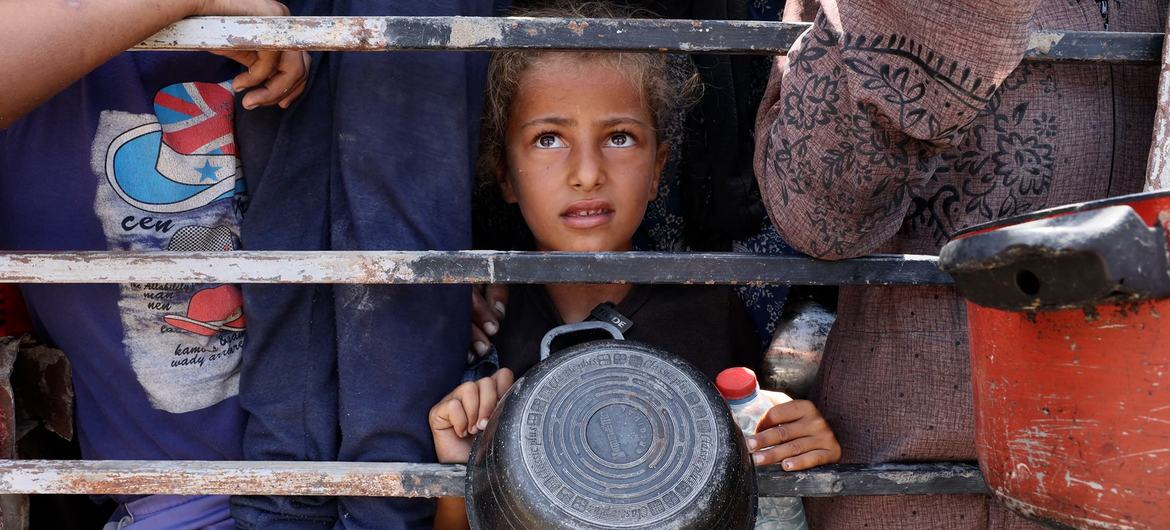A young girl from Gaza waiting to fill her container with lentils. A young girl from Gaza waiting to fill her container with lentils.