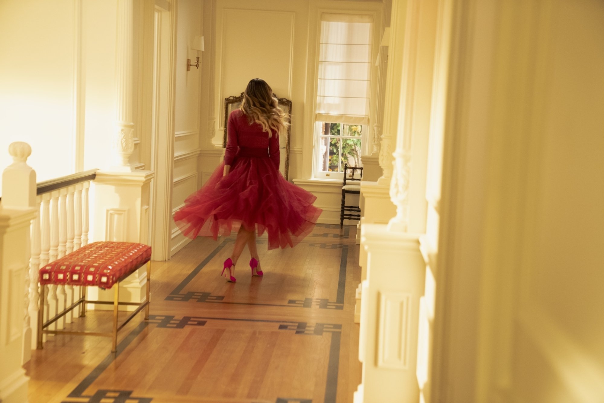 Carrie Bradshaw (Sarah Jessica Parker) twirling in a pink dress in the final episode of