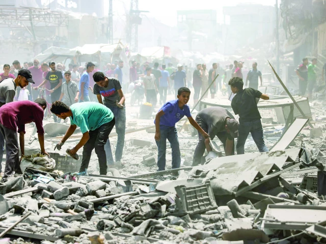 palestinians check the devastation following an israeli strike that hit gaza city s southern al zeitoun neighbourhood photo afp