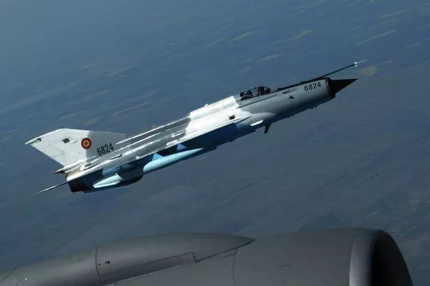 Romanian Army MIG 21 Lancer flies next to an US Air Force refueling plane