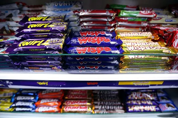Cadbury Twirl and Wispa chocolate confectionary bars, manufactured by Kraft Foods Inc., sit displayed for sale in a newsagent