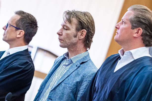 Christian Brueckner flanked by lawyers in court