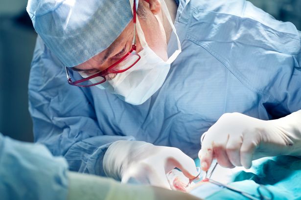 Picture shows medics undergoing tumour surgery
