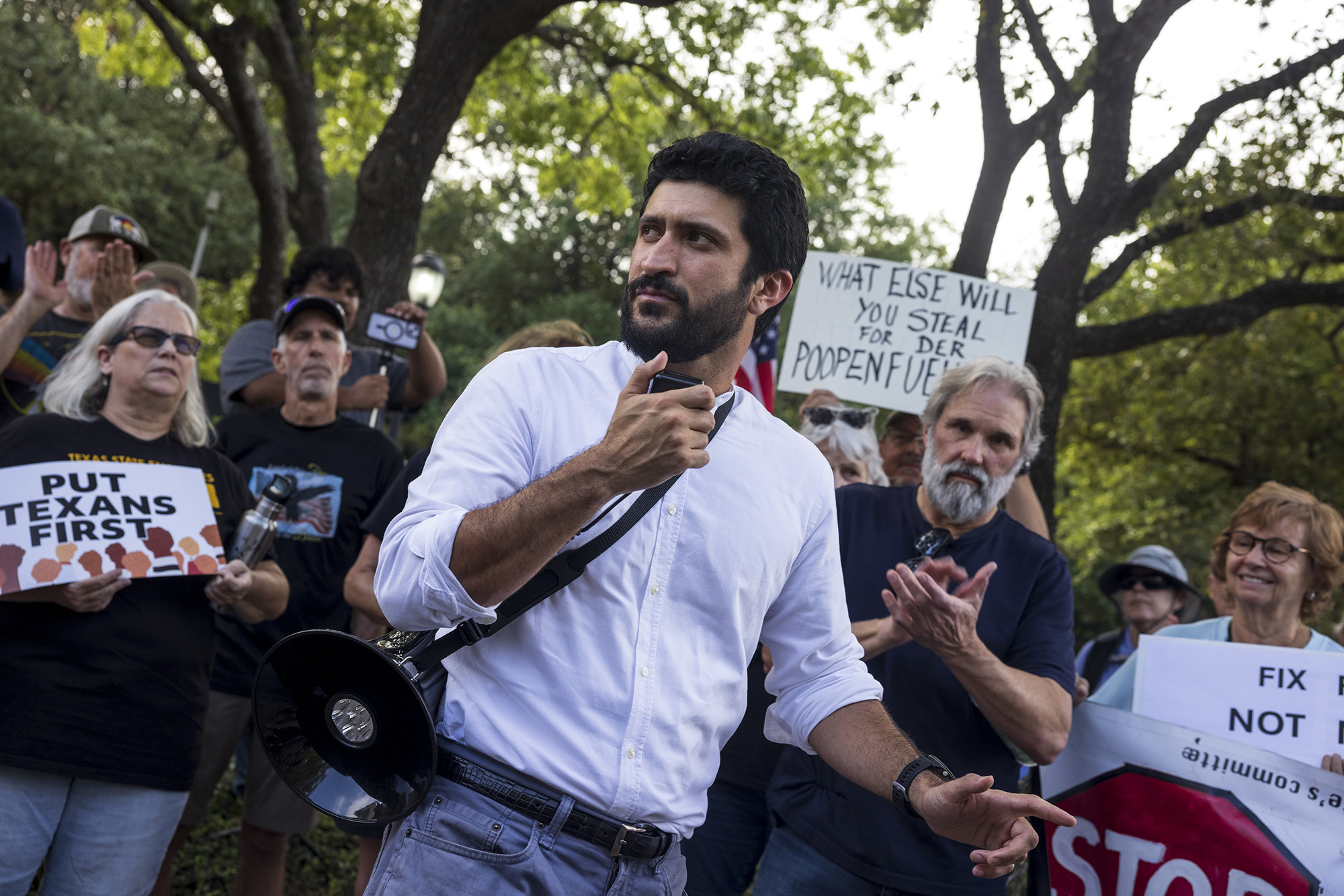 Greg Casar holding a megaphone among a crowd.