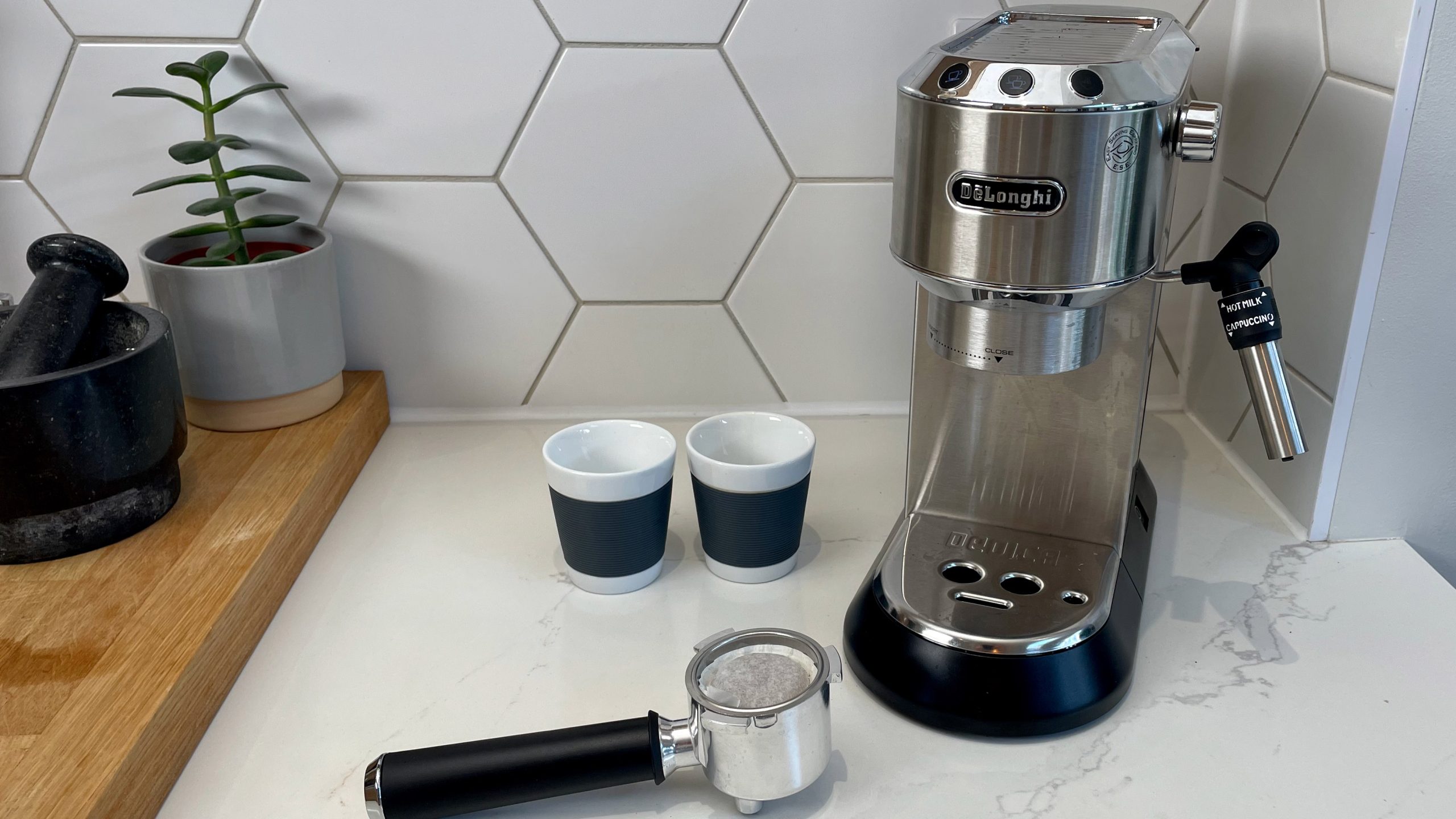 DeLonghi Dedica Style EC685 on a kitchen countertop with its accessories