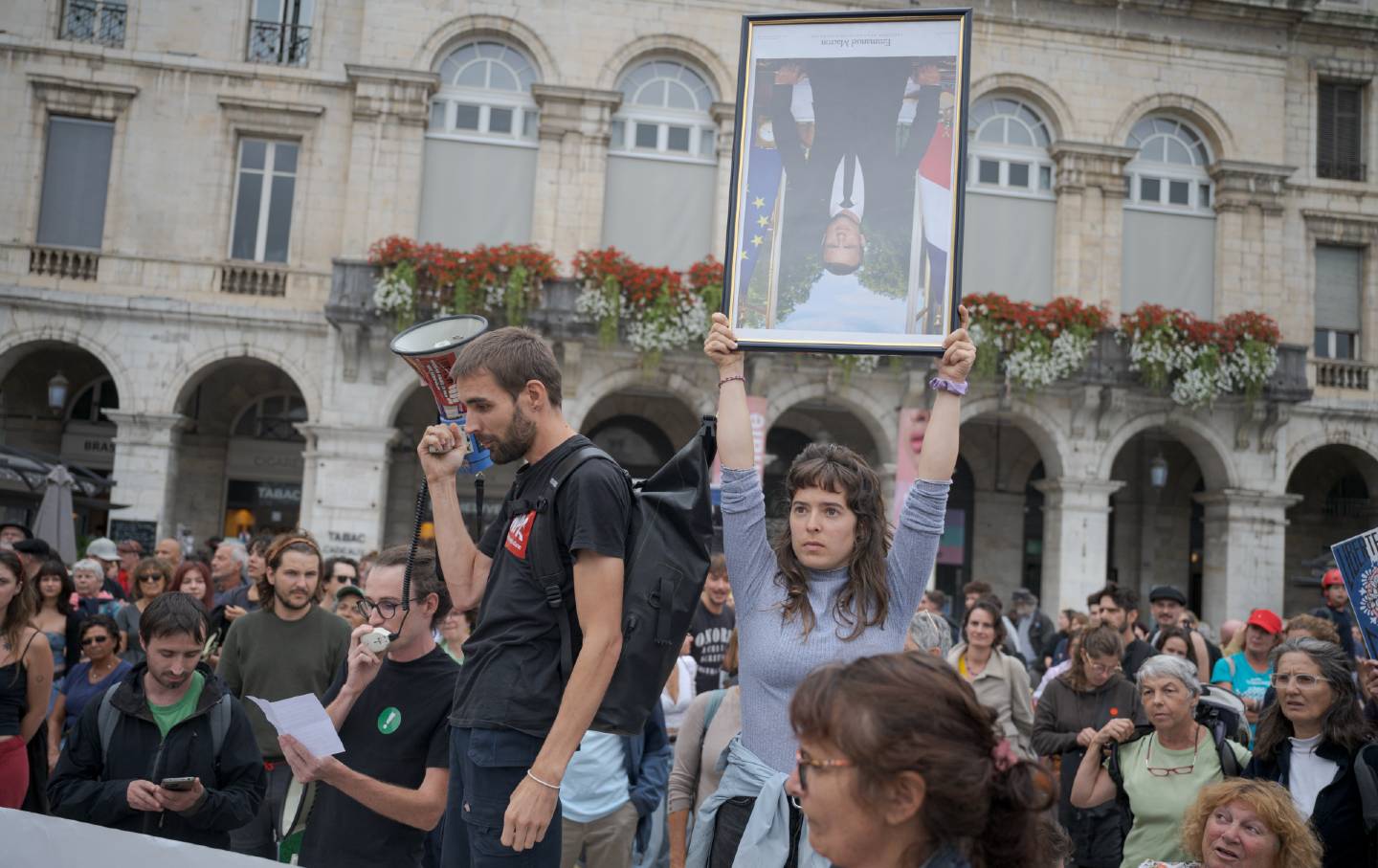 Protester holds portrait of Macron upside-down