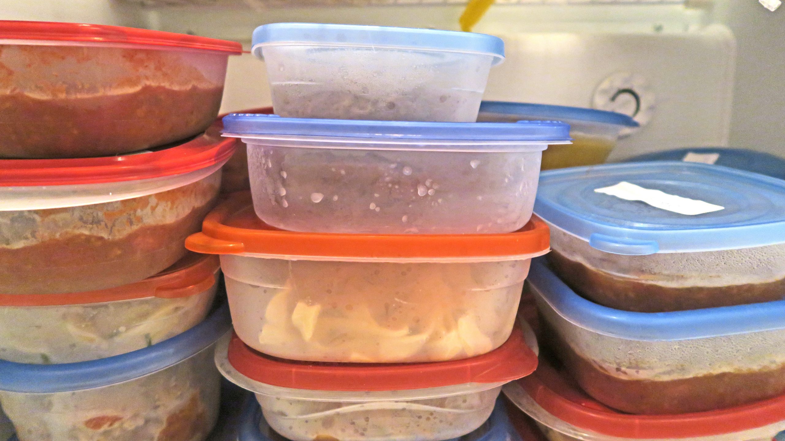 Containers full of leftover food in freezer