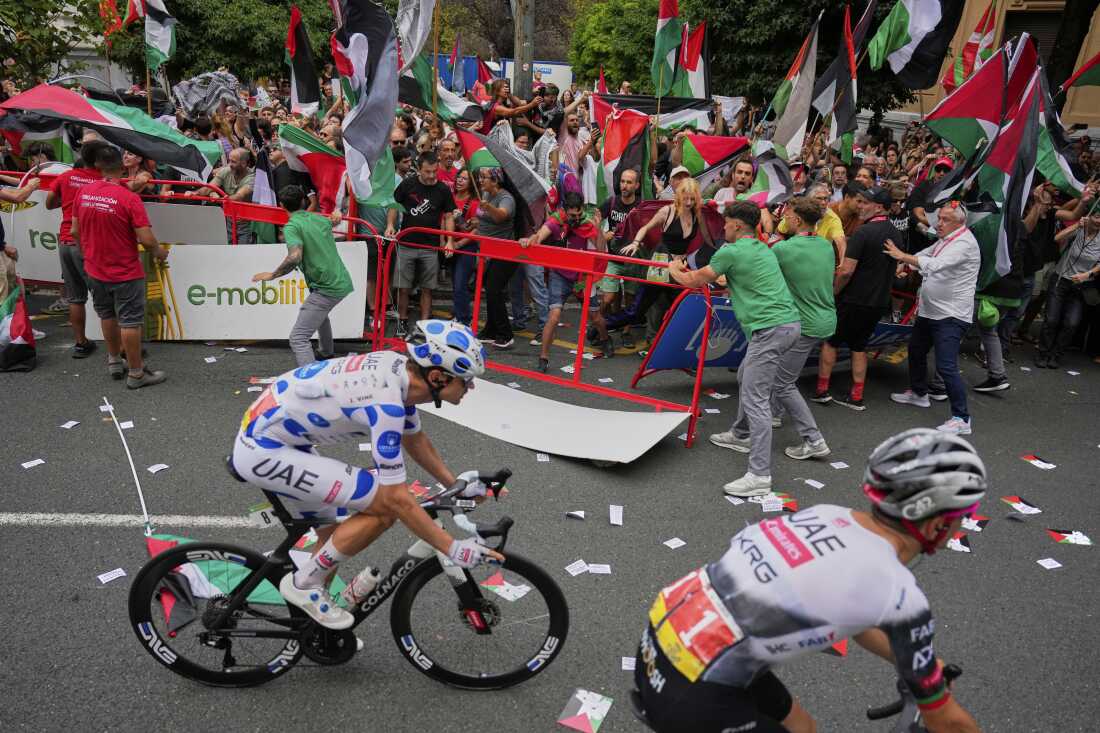 People hold Palestinian flags as they try to disrupt the eleventh stage of the Spanish Vuelta cycling race, from Bilbao to Bilbao, Spain, Wednesday, Sept. 3, 2025.