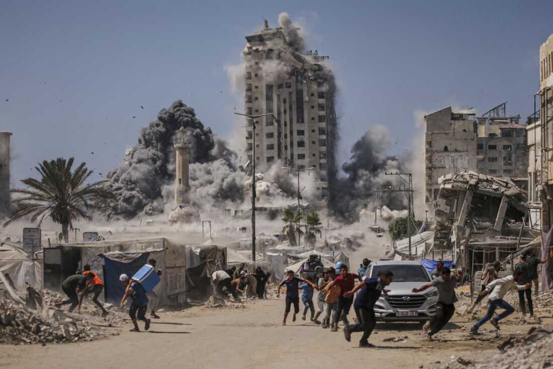 Palestinians run for cover during a Sept. 5 Israeli airstrike on a high-rise building in Gaza City after the Israeli army issued a warning.