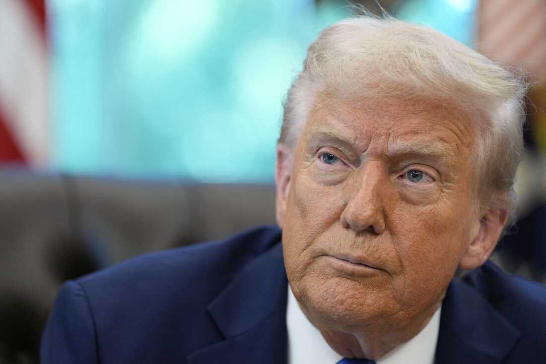 President Trump listens to a reporter