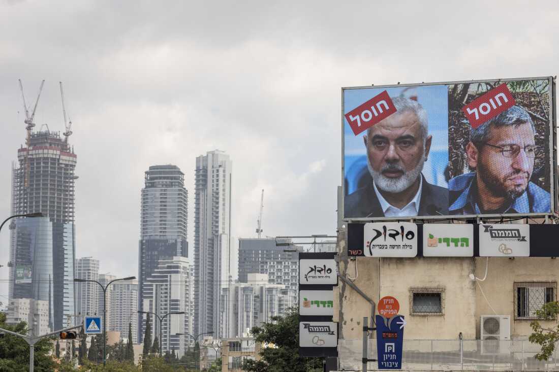 A billboard displays portraits of Hamas leaders Mohammed Deif and Ismail Haniyeh with the word