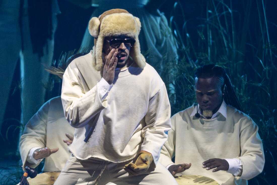 Singer and rapper Bad Bunny standing on stage with supporting musicians.
