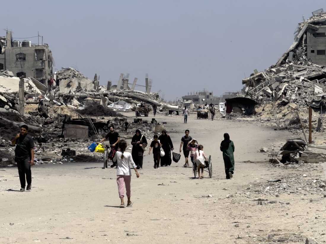 Families leave northern neighborhoods of Gaza City with the few items they can carry on Aug. 26, after Israeli tanks and airstrikes force them out.